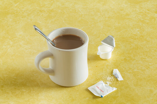 Retro Coffee Mug, Spoon, Sugar Packet And Creamer On Diner Counter