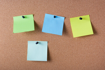 several colored note sheets pinned to the cork board