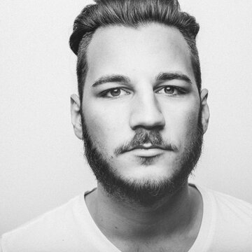 Headshot of a young bearded man