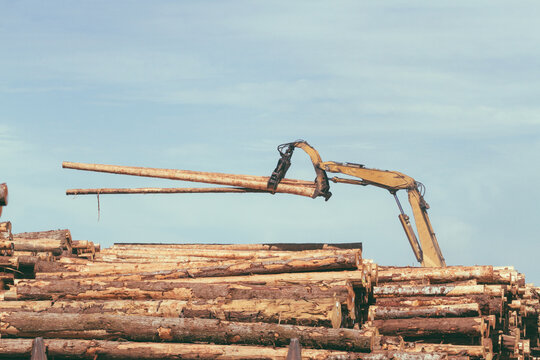 Vintage view of a logs being piled up by a timber tree grabber