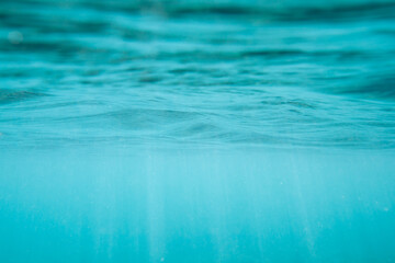 Calm transparent blue background under clear water in the open ocean.
