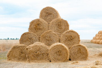 Pyramid of tightly twisted stacks of golden hay at the end of summer with place for copy space. Agriculture concept