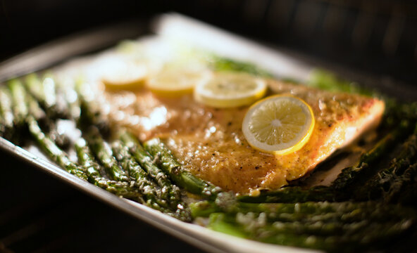 Roasted salmon and asparagus on parchment paper in the oven