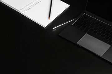 business layout, keyboard buttons and laptop fragments in black and silver, Notepad with white paper and pencil, background