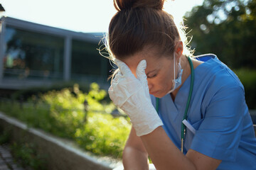 medical practitioner woman sitting outdoors near hospital