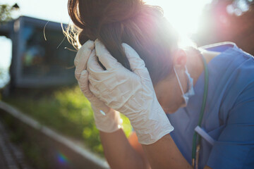 stressed modern physician woman sitting outdoors near hospital
