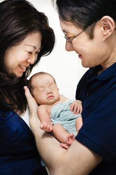 Asian parents, holding a newborn baby