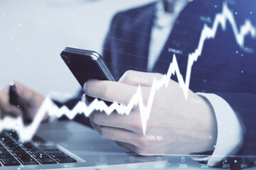 Multi exposure of man's hands holding and using a digital phone and forex graph drawing. Financial market concept.