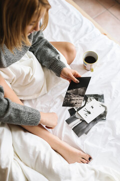 Young woman watching prints in the bed