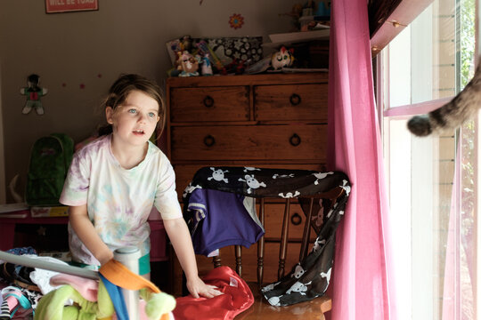 Little Girl in her Room Chasing a Cat