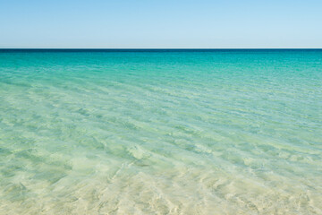 beautiful beach with golden sand and crystal clear aqua blue water