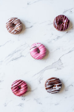five imperfect donuts on a marble background