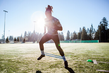 African American athlete training on a football field