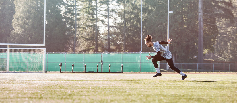 African American athlete running on a football field