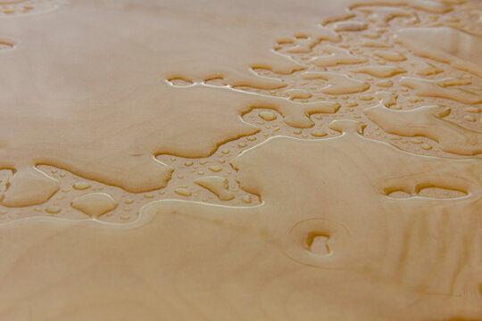 Wet wood background, water drops on plywood surface after the rain