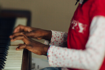 Hands of a black girl playing the piano