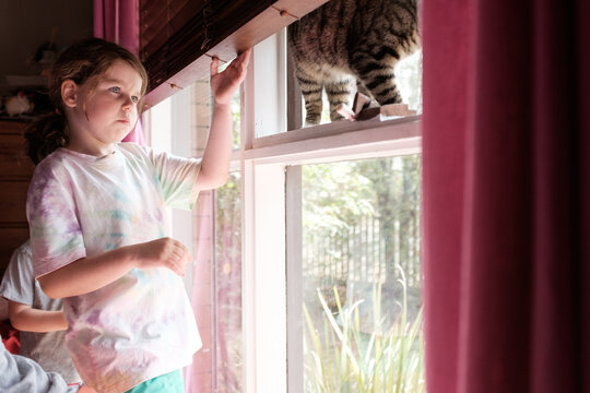 Girl in Bedroom with Cat on Windowsill