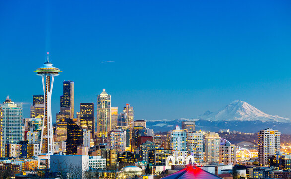 Characteristic horizontal view of downtown Seattle with Space Needle and Mount Rainier at sunset