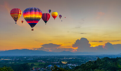Hot air balloon flying over City landscape and Doi Saket mountain in Chiang Mai, Thailand