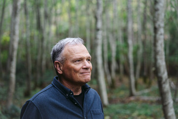 A peacefule, retired age man spending solitude in the forest.