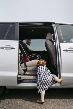 Little girl climbing into minivan