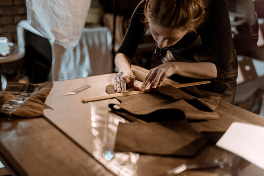 Woman puncturing leather