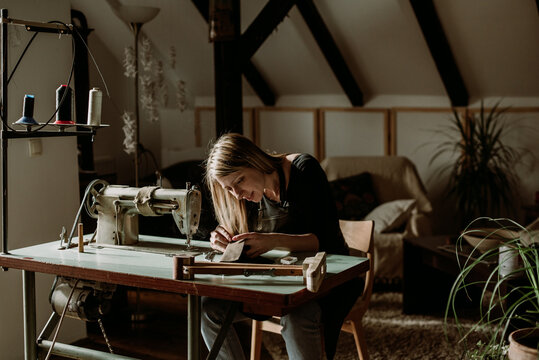 Woman puncturing leather