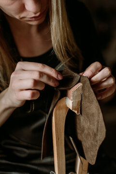 Woman puncturing leather