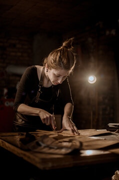 Woman puncturing leather
