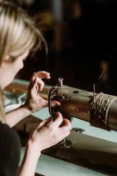 Woman puncturing leather