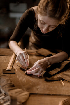 Woman puncturing leather