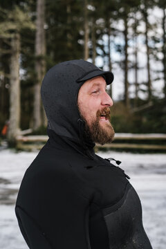 Smiling, cold surfer in wetsuit after extreme cold water surf session.