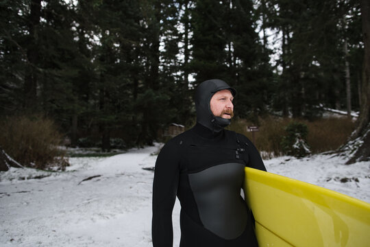 Surfer guy checking waves on beach in winter