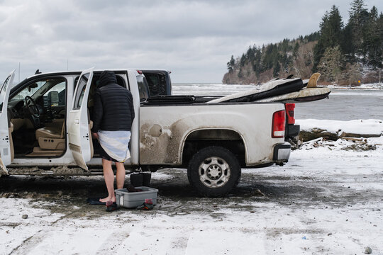 Surfer changing out of wetsuit in winter.