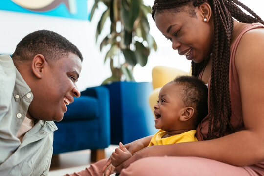 African American parents playing with baby at home