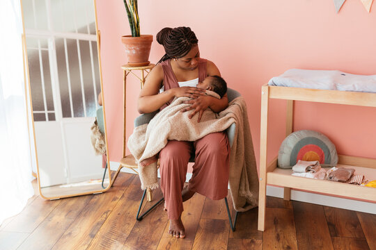 African American mother embracing sleeping baby