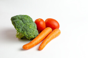 Grupo de verduras en primer plano sobre fondo blanco, tomates, zanahorias, y brócoli, aislados, recortable.