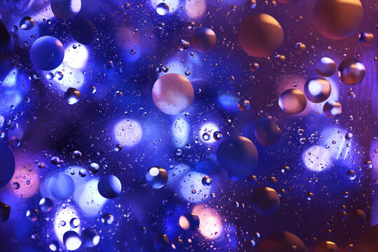 Oil bubbles floating in colored water - Macro