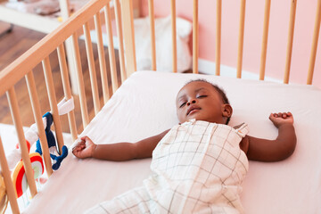 Black baby sleeping in crib