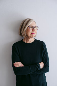 Portrait Of Mature Woman Wearing Glasses On Seamless White Studio Background