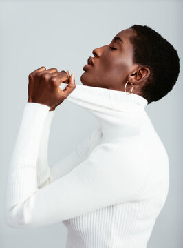 A Black Woman in Profile Pulling on Turtleneck