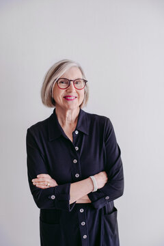 Portrait of mature woman wearing glasses on seamless white studio background