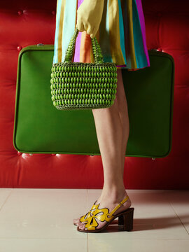 Woman holding vintage handbag and suitcase