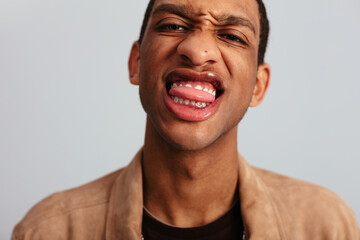 Black man sticking out the tongue in studio