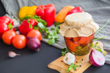 Jars of tasty pickled vegetables on a table. Creative atmospheric decoration.