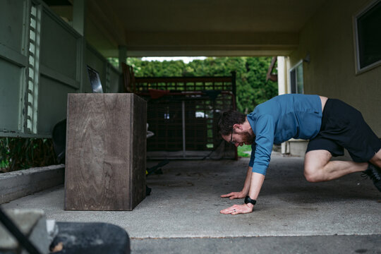 Man working out in driveway at home.