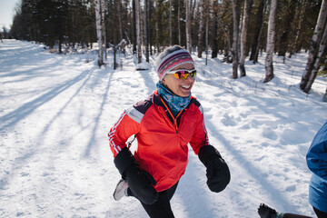 Group of women running on snowy trail in winter.