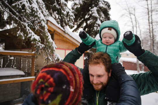 Young family spending time together in the snow dong shoulder ri