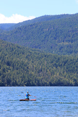 Fototapeta na wymiar Paddle boarding in mountain lake 