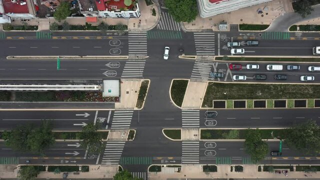 Vista a&eacute;rea cenital sobre el cruce peatonal de Avenida Chapultepec y Varsovia en la Ciudad de M&eacute;xico. El drone descendiendo lentamente